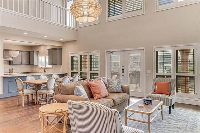 314 Bahia Mar Prt, Aransas, TX 78373 - living room with an inviting chandelier, light wood-style flooring, a towering ceiling, and french doors