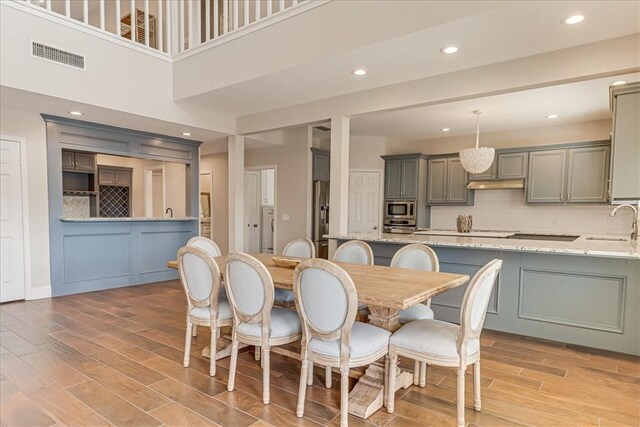 314 Bahia Mar Prt, Aransas, TX 78373 - dining space with light wood finished floors, visible vents, recessed lighting, and a decorative wall
