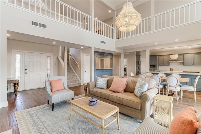 314 Bahia Mar Prt, Aransas, TX 78373 - living area with visible vents, wood finished floors, a high ceiling, and stairs
