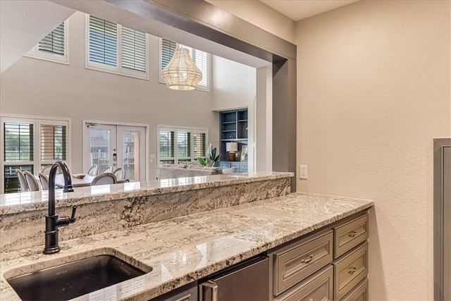 314 Bahia Mar Prt, Aransas, TX 78373 - kitchen featuring light stone counters, open floor plan, french doors, and a sink