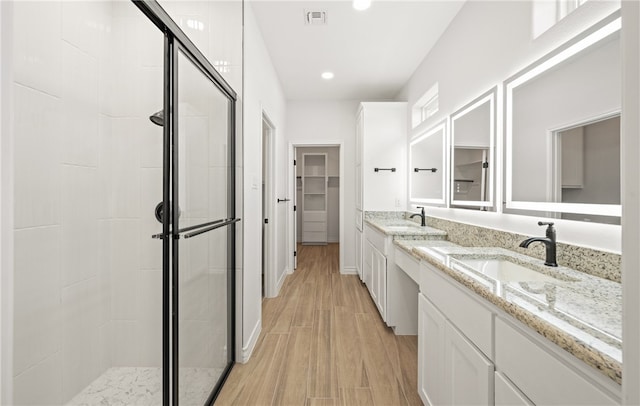 6202 Olivia St, Corpus Christi, TX 78415 - bathroom featuring a shower stall, wood finished floors, double vanity, a walk in closet, and recessed lighting
