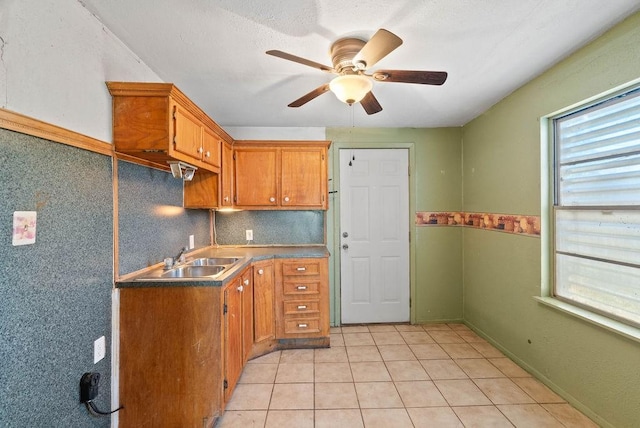 925 Hazel Dr, Corpus Christi, TX 78412 - kitchen featuring a ceiling fan, brown cabinets, light tile patterned flooring, and decorative backsplash
