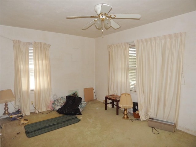 carpeted bedroom featuring multiple windows and ceiling fan