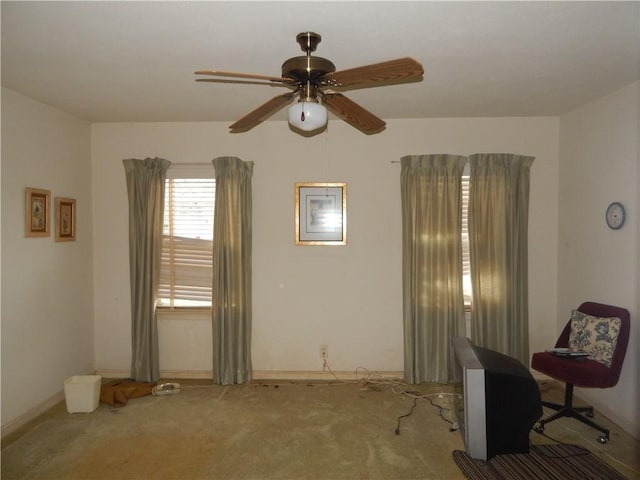 interior space with carpet, baseboards, and a ceiling fan