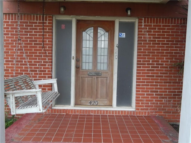 doorway to property with brick siding
