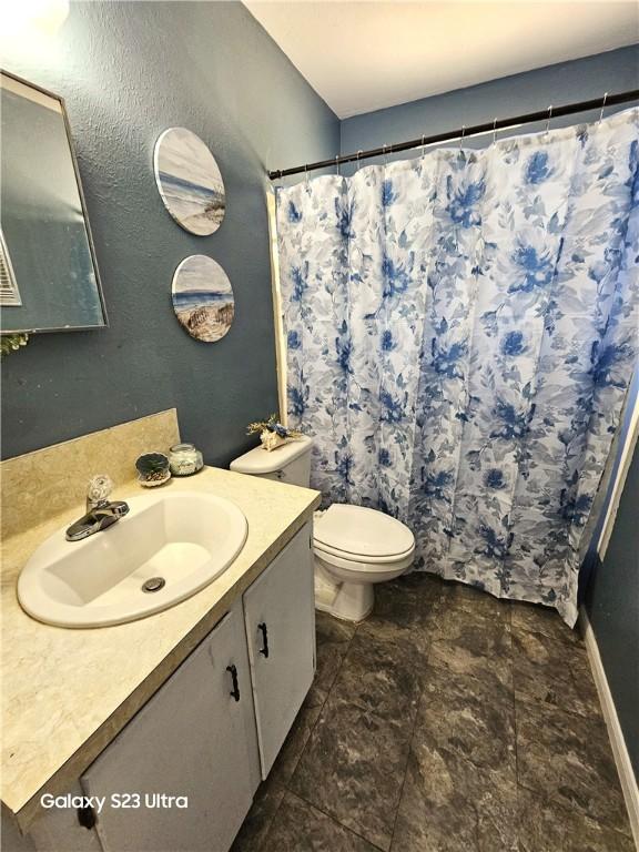 1330 Red Bird Dr, Rockport, TX 78382 - bathroom featuring vanity, toilet, a shower with shower curtain, and baseboards