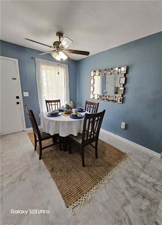1330 Red Bird Dr, Rockport, TX 78382 - dining area featuring a ceiling fan, baseboards, and a textured ceiling