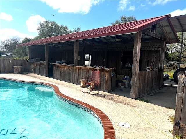 view of pool with exterior bar and a patio