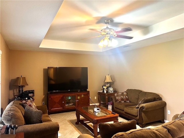 living room featuring ceiling fan and a raised ceiling