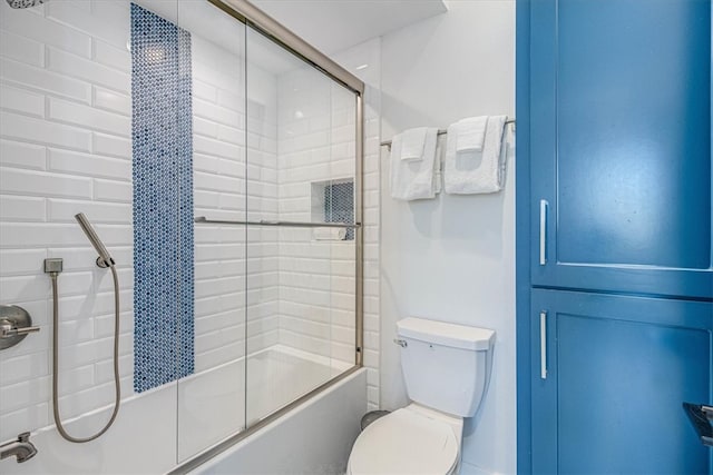 bathroom featuring combined bath / shower with glass door and toilet