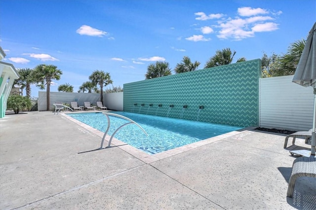 community pool with fence and a patio