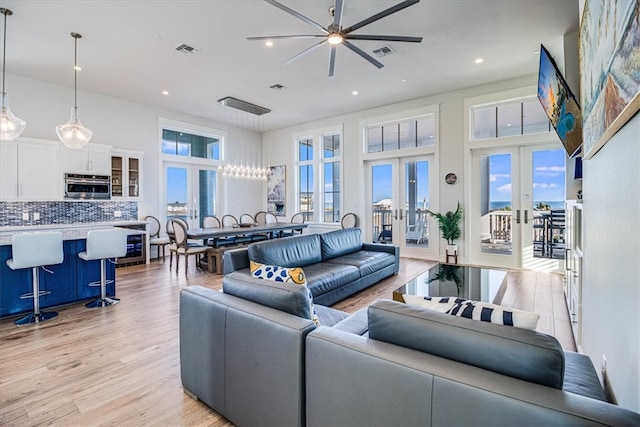 living room featuring a high ceiling, visible vents, and french doors