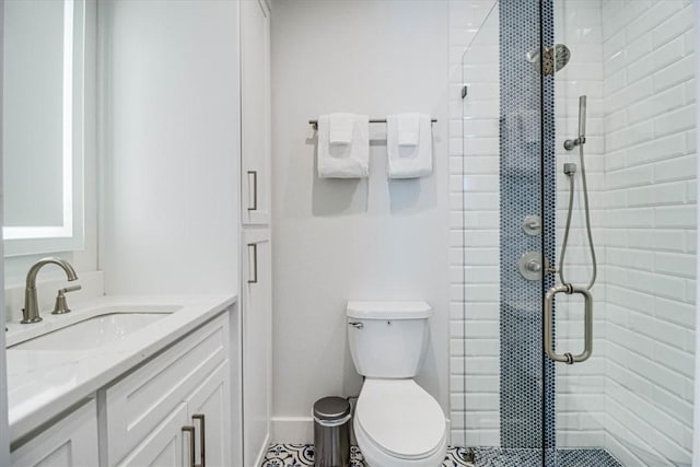 bathroom featuring toilet, a shower stall, baseboards, and vanity