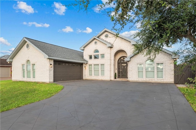8230 Excalibur, Corpus Christi, TX 78414 - french country home featuring asphalt driveway, an attached garage, brick siding, a front yard, and a shingled roof