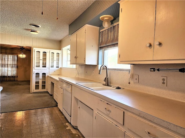 128 Granby Pl, Portland, TX 78374 - kitchen featuring a sink, light countertops, a textured ceiling, white cabinets, and dishwasher