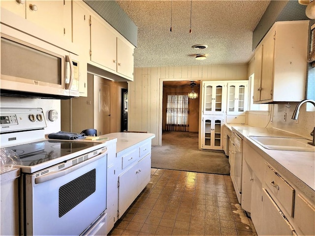 128 Granby Pl, Portland, TX 78374 - kitchen with white appliances, a sink, light countertops, dark carpet, and white cabinets