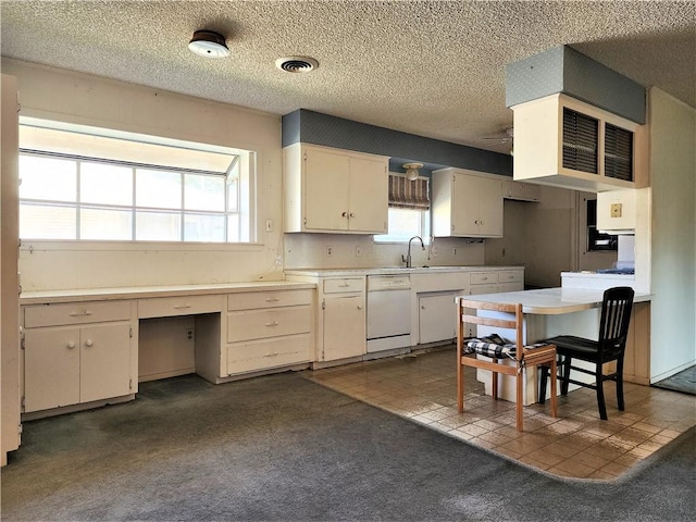 128 Granby Pl, Portland, TX 78374 - kitchen featuring white dishwasher, a textured ceiling, a sink, dark carpet, and light countertops