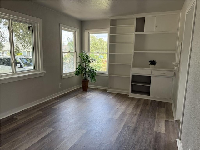624 E Kenedy Ave, Kingsville, TX 78363 - unfurnished living room featuring dark wood-type flooring and a textured ceiling