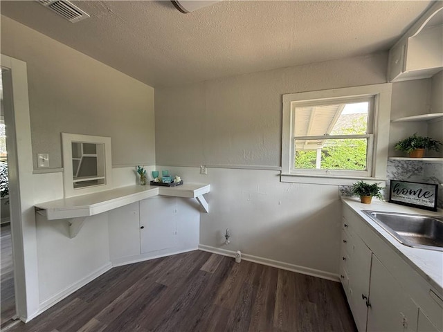 624 E Kenedy Ave, Kingsville, TX 78363 - kitchen with dark wood-style floors, a textured ceiling, light countertops, and open shelves