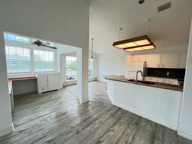 kitchen with hardwood / wood-style flooring, ceiling fan, white cabinets, white fridge, and pendant lighting