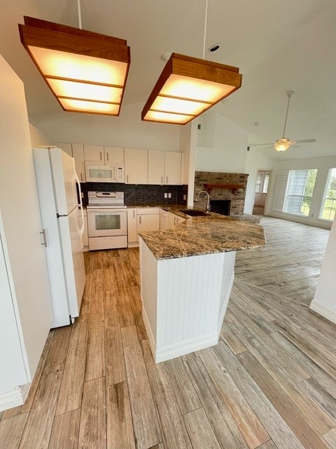 kitchen featuring white appliances, sink, light hardwood / wood-style floors, white cabinets, and kitchen peninsula