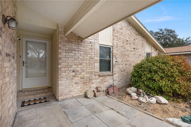 view of exterior entry with brick siding