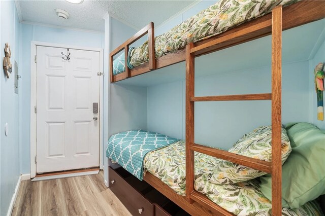 bedroom featuring light hardwood / wood-style floors, a textured ceiling, and a closet