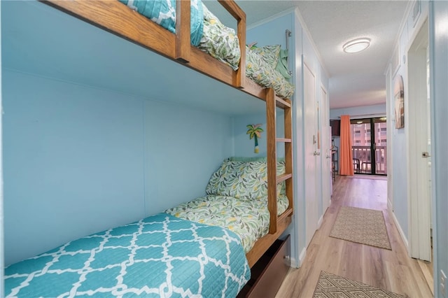 bedroom with a textured ceiling and light hardwood / wood-style floors