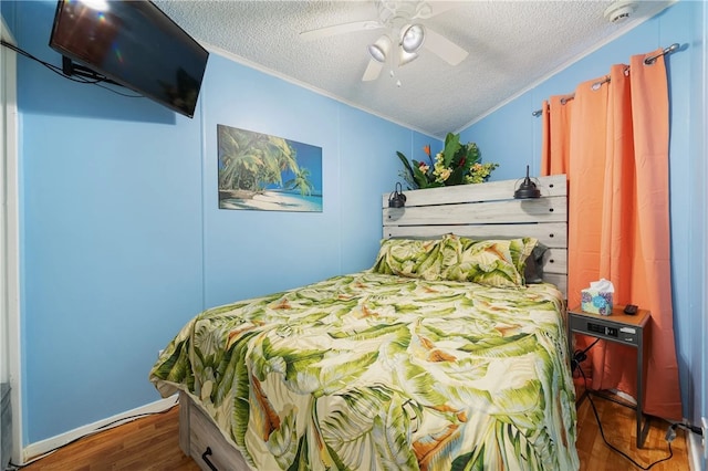 bedroom featuring a textured ceiling, hardwood / wood-style flooring, ceiling fan, and crown molding