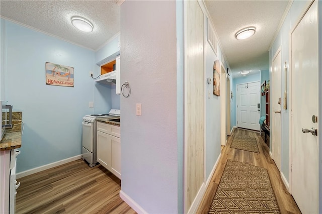 hall featuring a textured ceiling, light hardwood / wood-style floors, and crown molding