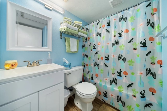 full bathroom featuring hardwood / wood-style flooring, a textured ceiling, vanity, shower / bath combo, and toilet