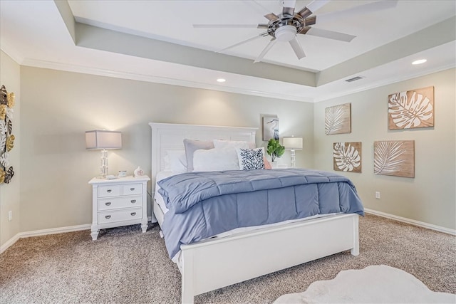 bedroom featuring ornamental molding, a tray ceiling, carpet flooring, and ceiling fan