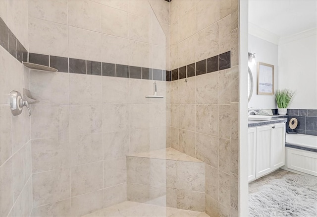 bathroom featuring vanity, a tile shower, and crown molding