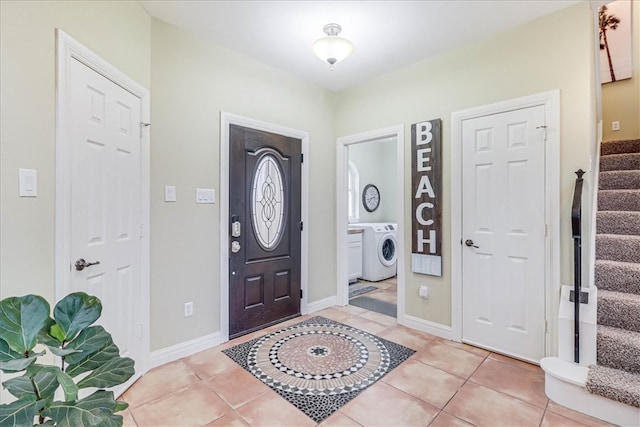 entrance foyer with washer / clothes dryer and light tile patterned floors