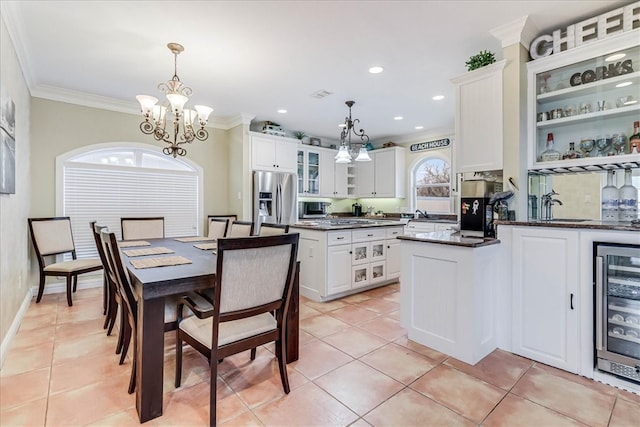 kitchen featuring stainless steel appliances, white cabinets, light tile patterned floors, pendant lighting, and wine cooler