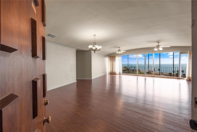 empty room featuring a water view, wood-type flooring, floor to ceiling windows, and ceiling fan with notable chandelier