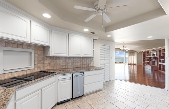 kitchen with ceiling fan with notable chandelier, white cabinets, decorative backsplash, a raised ceiling, and black electric cooktop