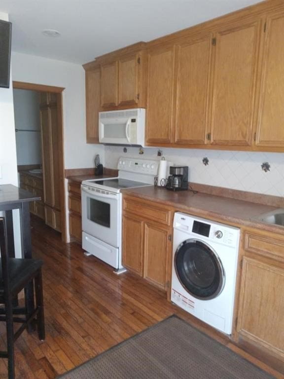 kitchen with washer / dryer, white appliances, and dark wood-type flooring