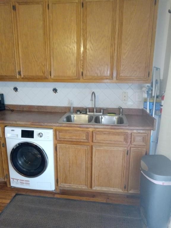 laundry area with cabinets, washer / clothes dryer, and sink