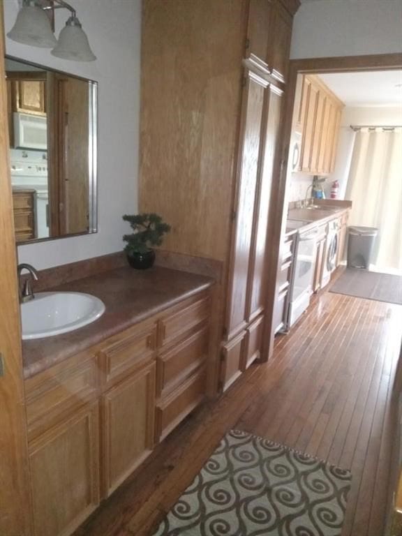 interior space featuring washer / clothes dryer, vanity, and hardwood / wood-style flooring