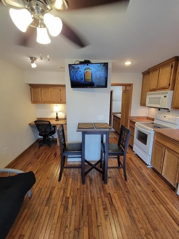 kitchen featuring dark hardwood / wood-style flooring, ceiling fan, and white appliances