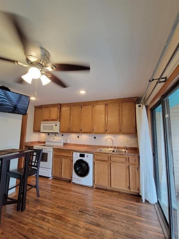 kitchen with washer / clothes dryer, sink, ceiling fan, dark wood-type flooring, and white appliances