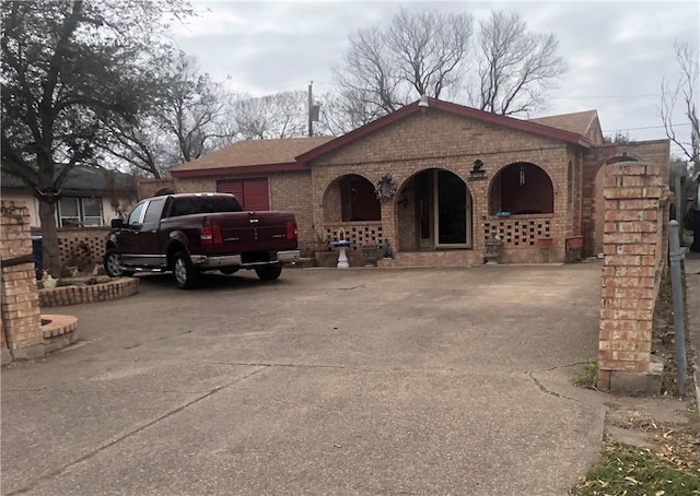 1705 Sherman St, Corpus Christi, TX 78416 - view of front of home with brick siding, concrete driveway, a garage, and covered porch