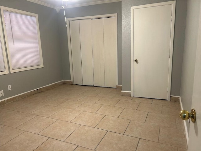 1705 Sherman St, Corpus Christi, TX 78416 - unfurnished bedroom featuring ornamental molding, a closet, and light tile patterned flooring