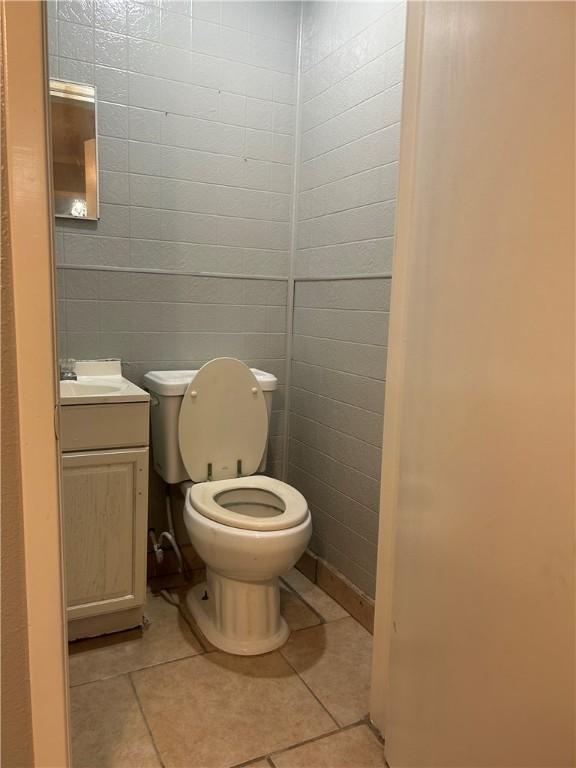 1705 Sherman St, Corpus Christi, TX 78416 - half bathroom with vanity, tile patterned floors, and tile walls