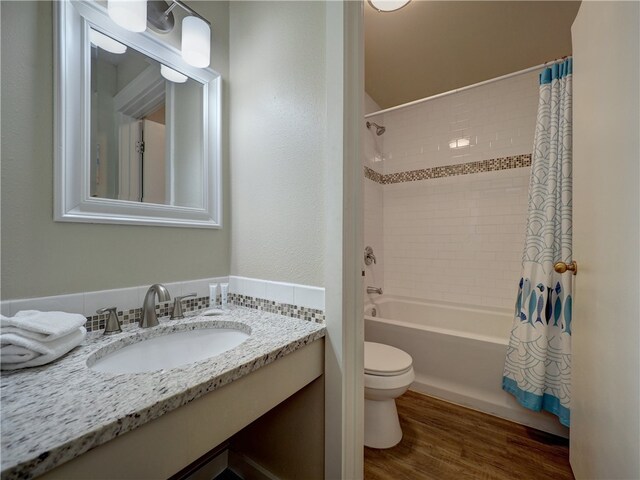 full bathroom featuring shower / bath combo, wood-type flooring, vanity, and toilet