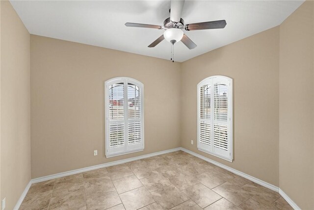 unfurnished room featuring a healthy amount of sunlight, baseboards, and ceiling fan