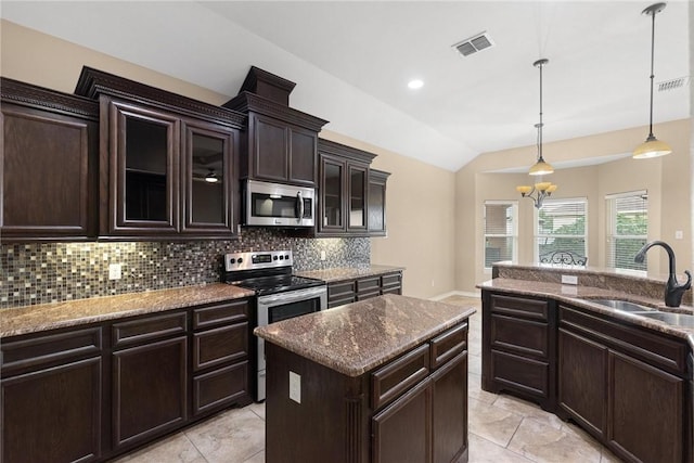 kitchen featuring visible vents, lofted ceiling, a sink, stainless steel appliances, and tasteful backsplash