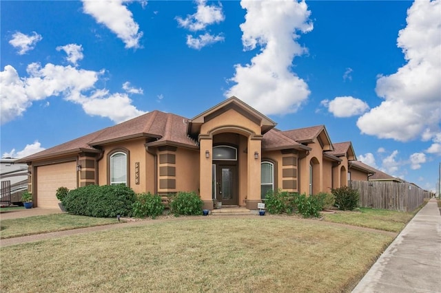 view of front of house featuring stucco siding, a front lawn, a garage, and fence