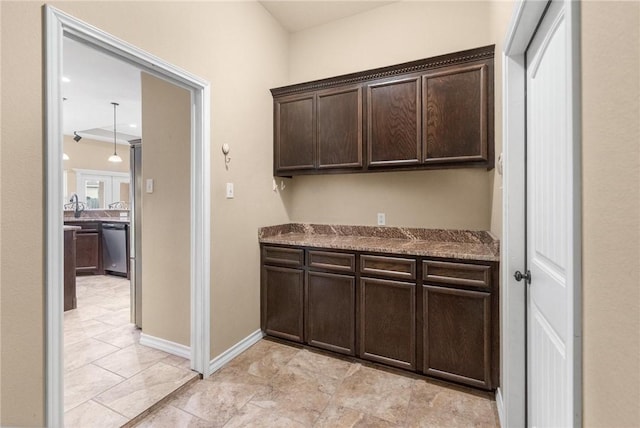 bar featuring dark brown cabinetry, light stone countertops, and dishwasher